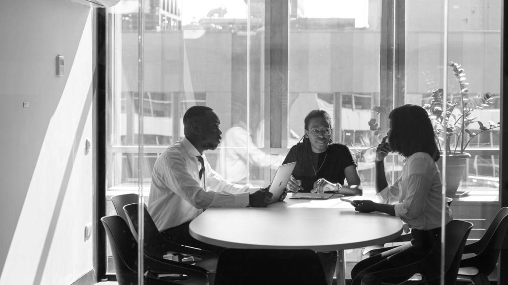 Colleagues meeting at a round table beside a window
