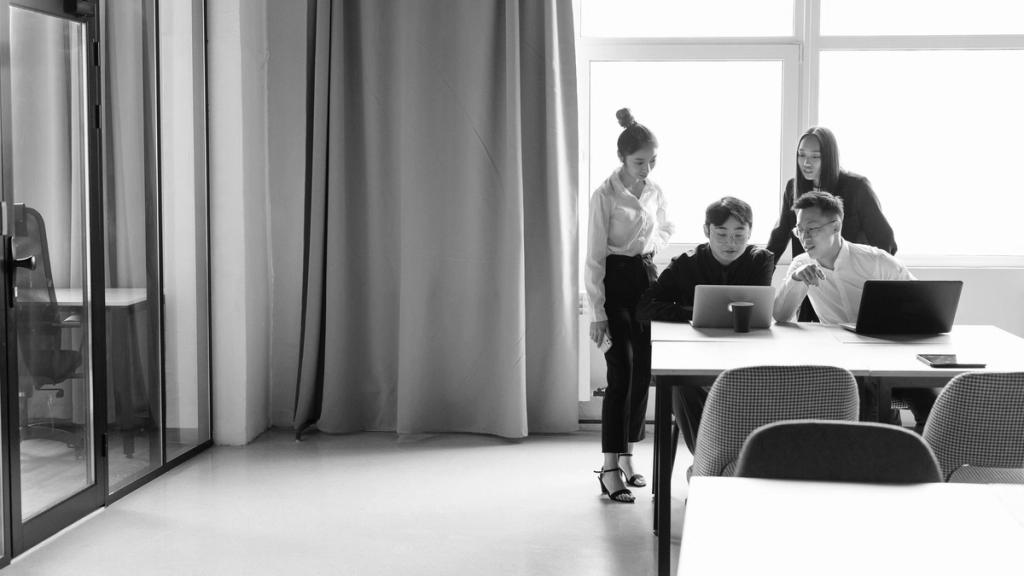 Colleagues working at a table in a bright, open-plan office