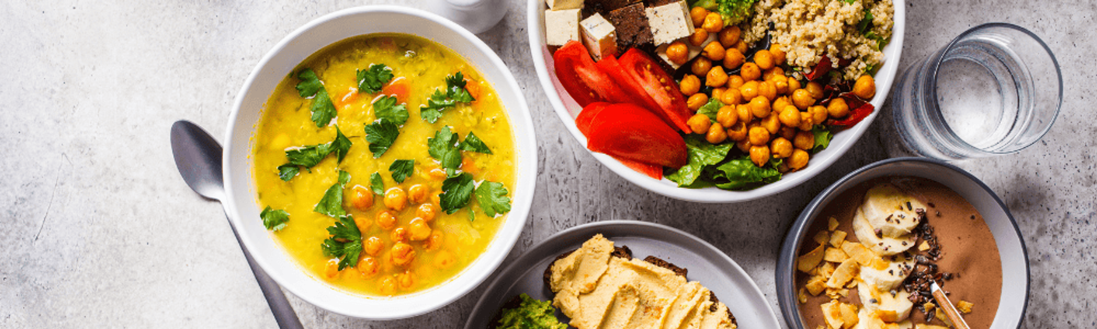 Zupa z soczewicy, hummus i miski z warzywami i ciecierzycą