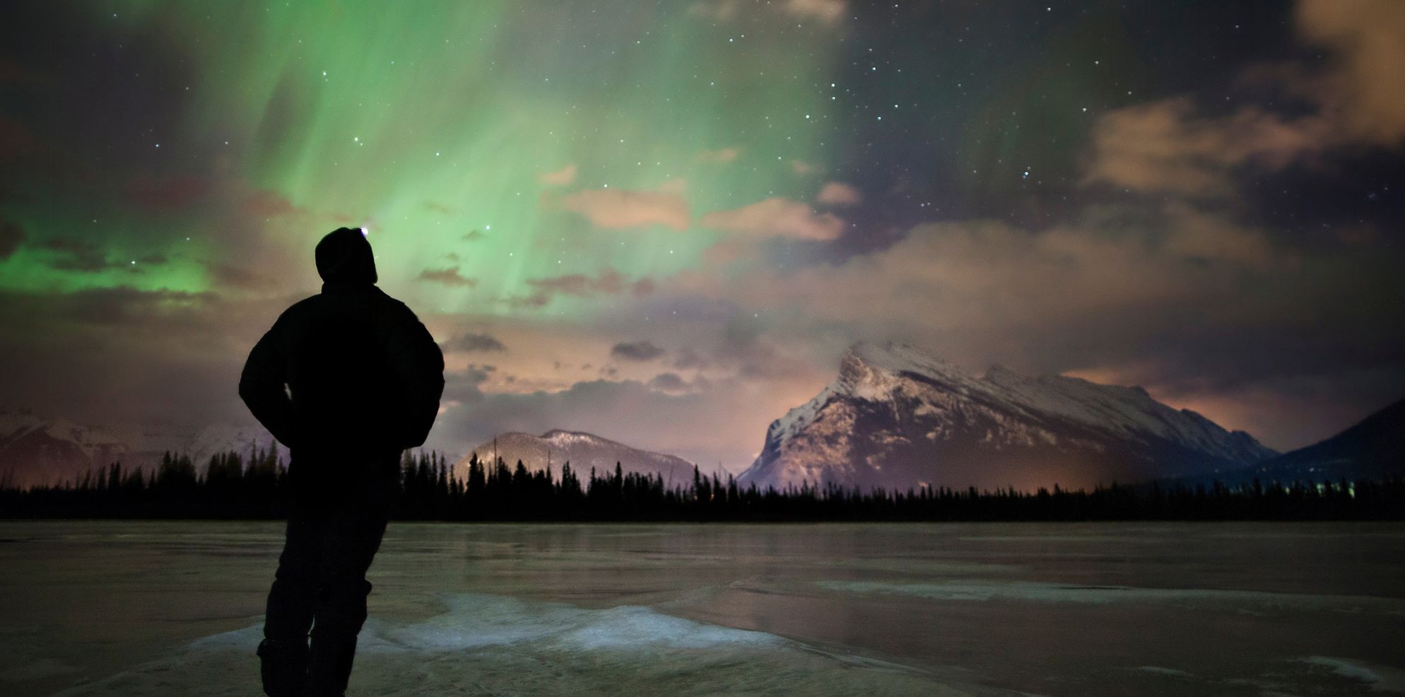A man watches the Northern Lights above the skies of Banff and Lake Louise