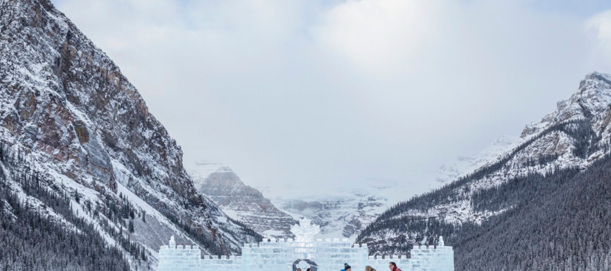 Group of friends skating on Lake Louise in front of an ice castle