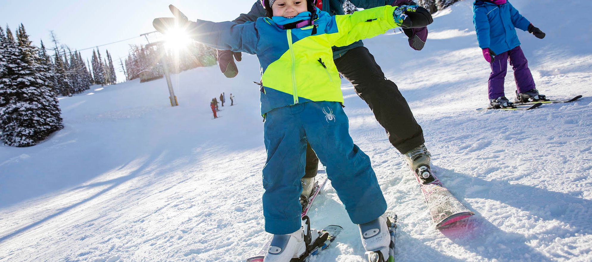 A little kid and their mom go downhill skiing at Banff Sunshine Village in Banff National Park.