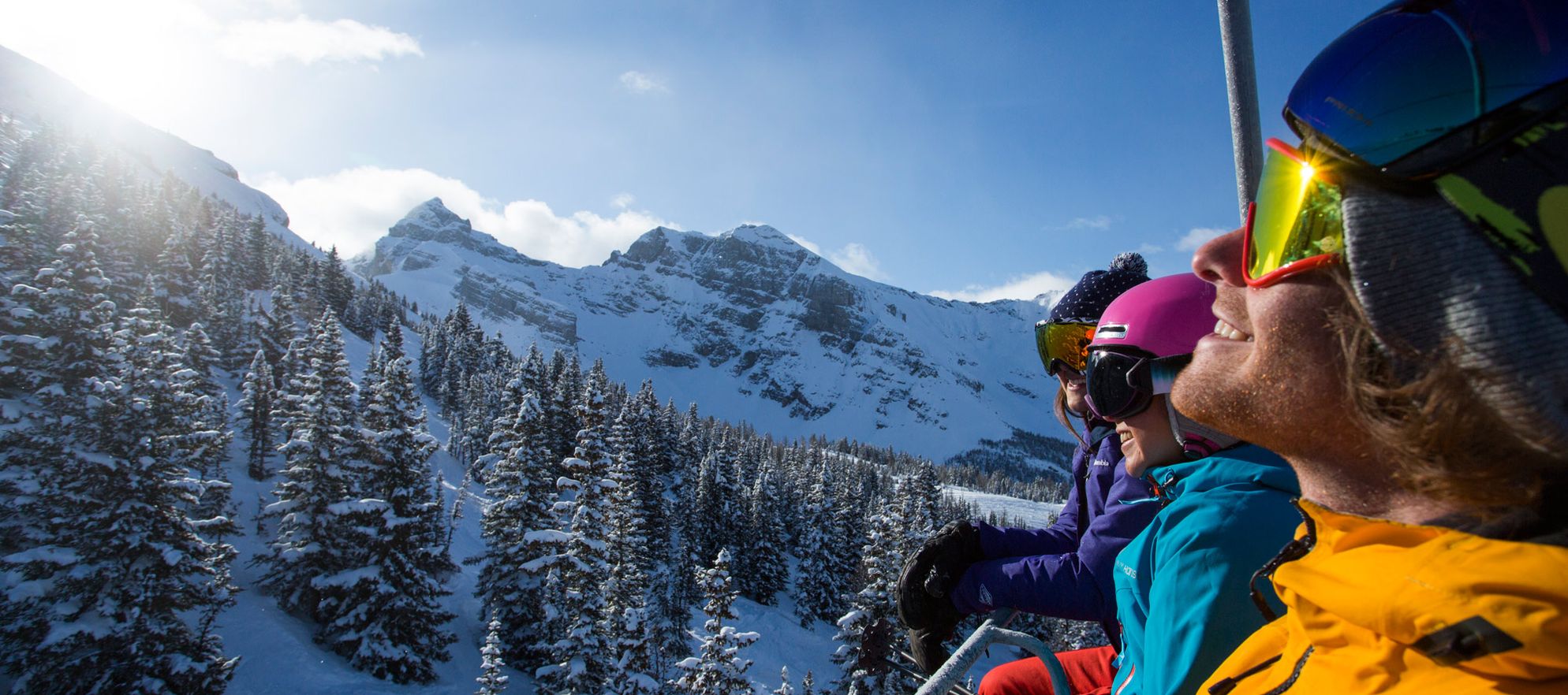 A group of friends soaks in the spring sun while riding the chairlift in Banff National Park, AB