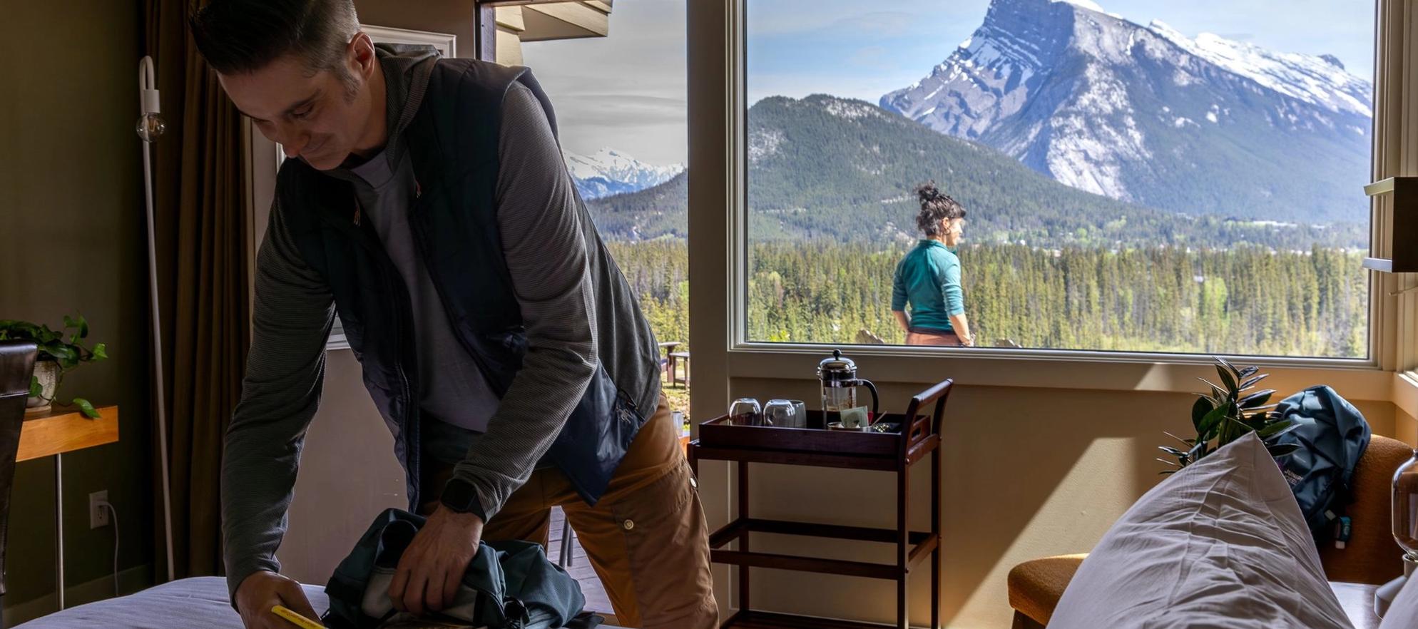 A guest packs their complimentary adventure gear with panoramic views over Banff behind