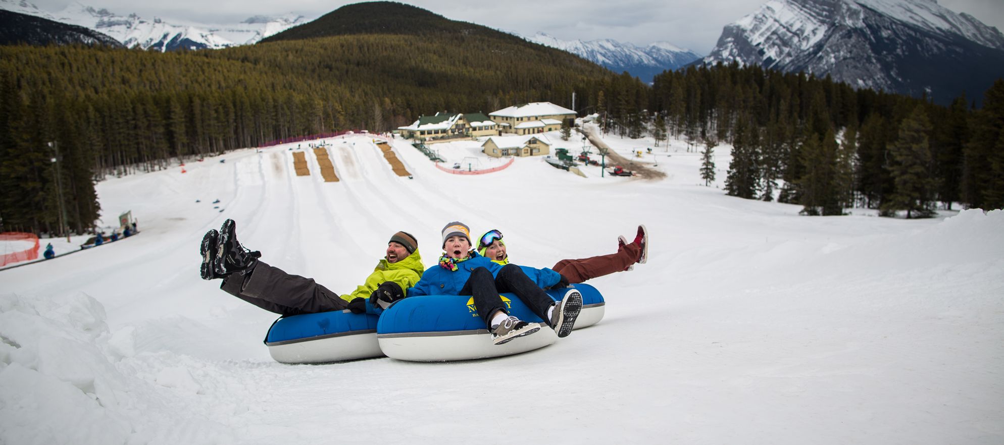 A family tubes on the snowy slopes of Banff and Lake Louise, AB