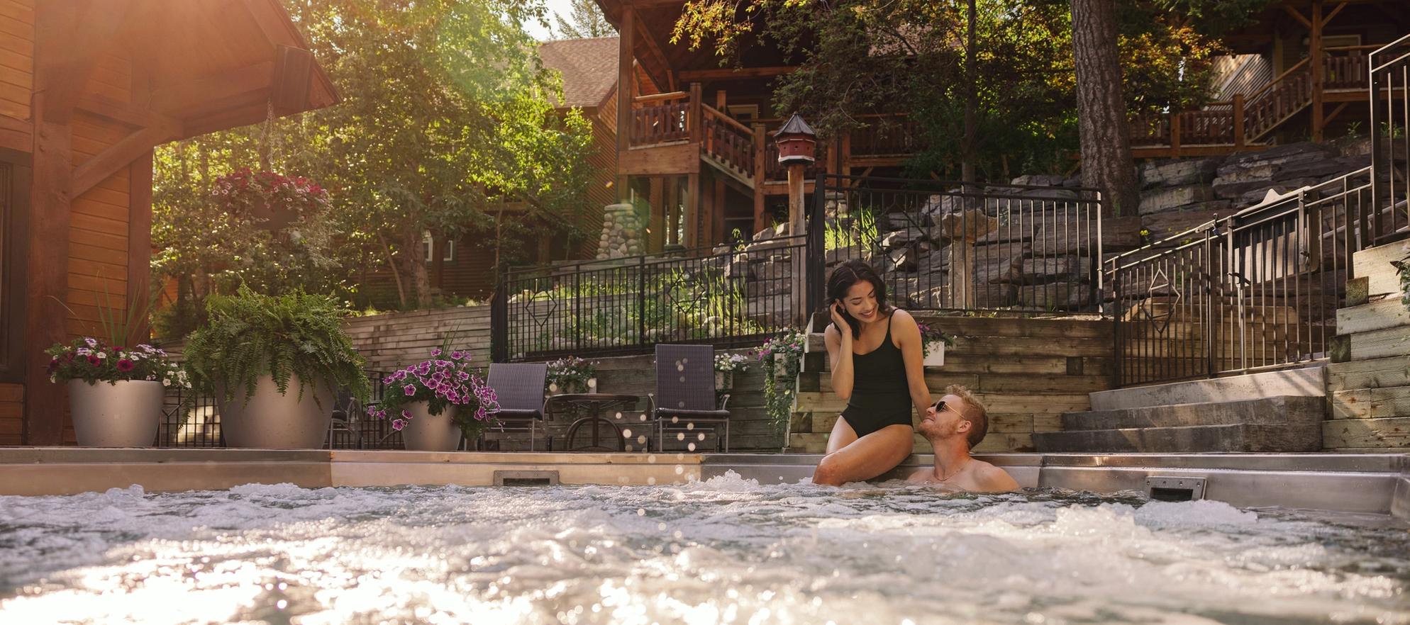 Two people in the hot tub on a summer day at Buffalo Mountain Lodge