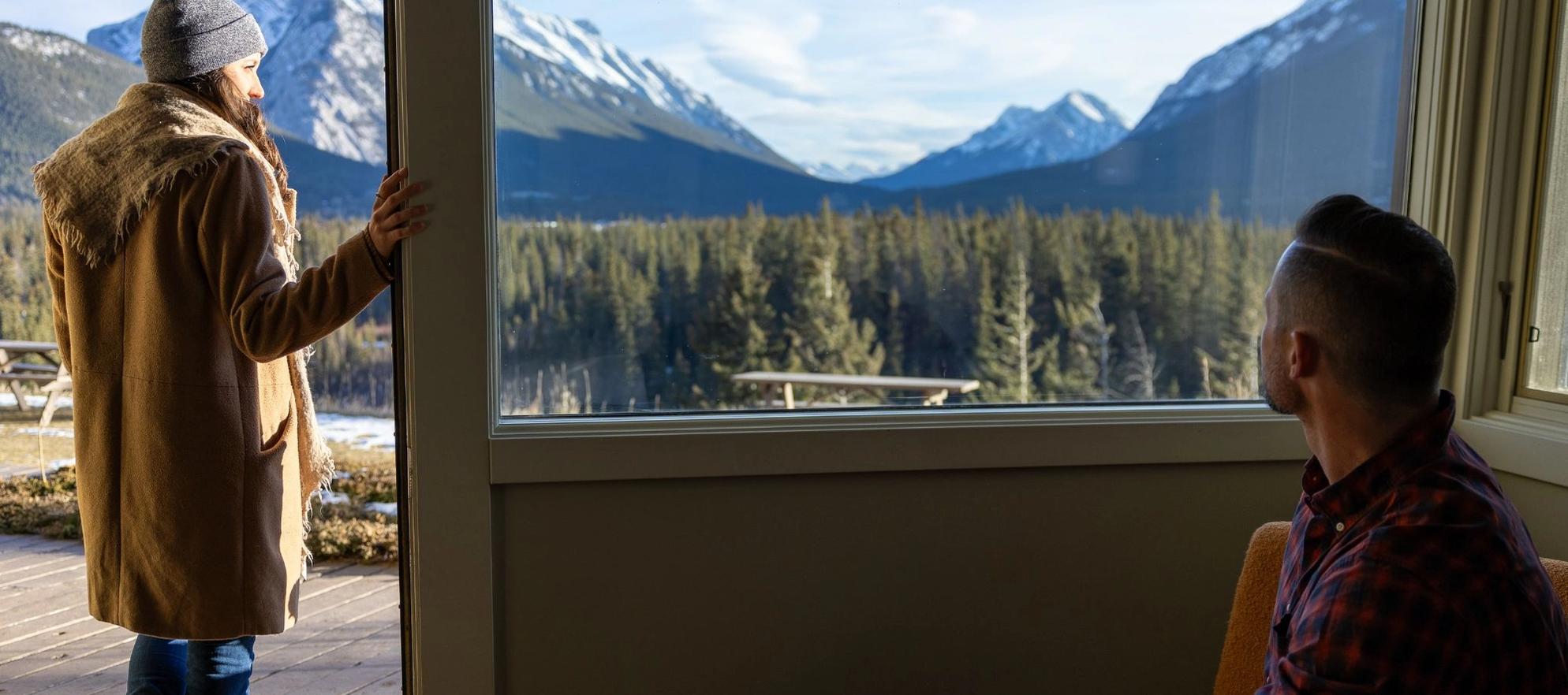 A guest enjoys their coffee as she wakes up with panoramic views over Banff