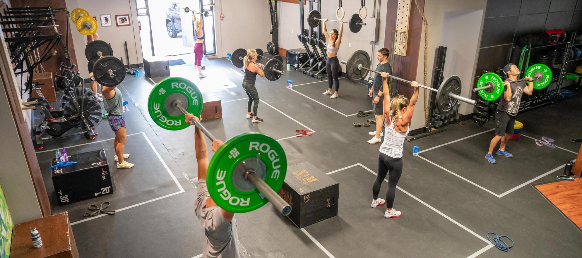 A group of people participating in a CrossFit class at Summit Lifestyle & Performance