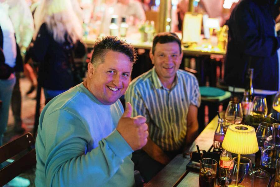 Gäste an der Bar im Das Glockenspiel bei Nacht