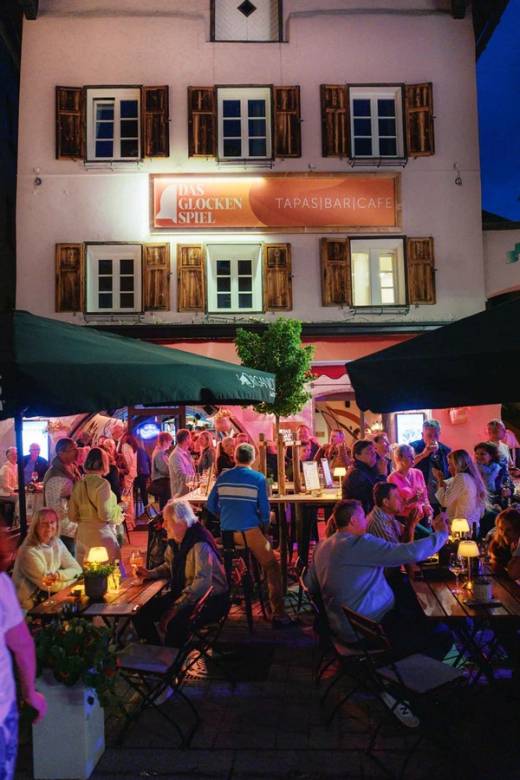 Gäste an der Bar im Das Glockenspiel bei Nacht