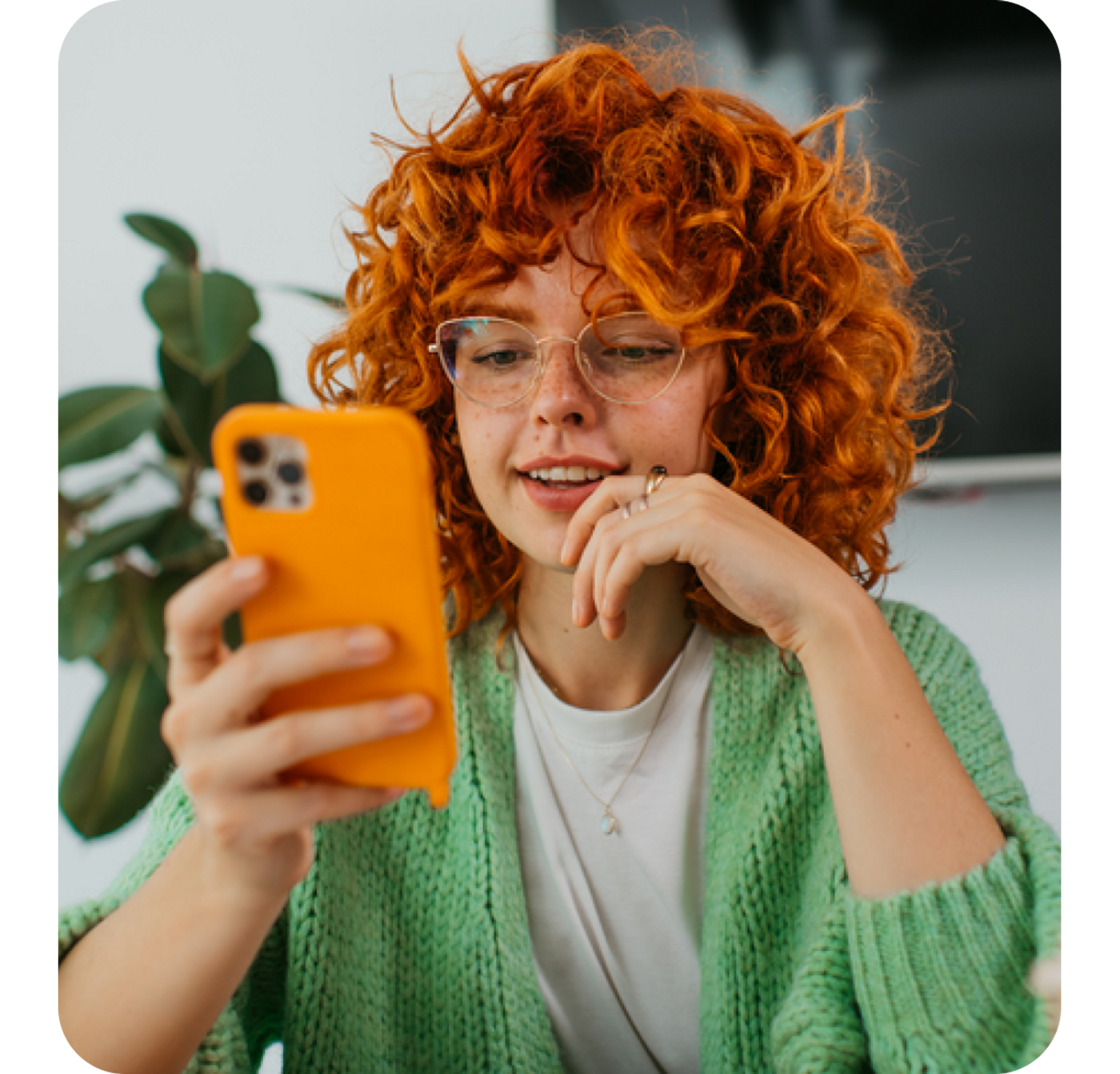 A photo of a woman smiling and looking at a phone