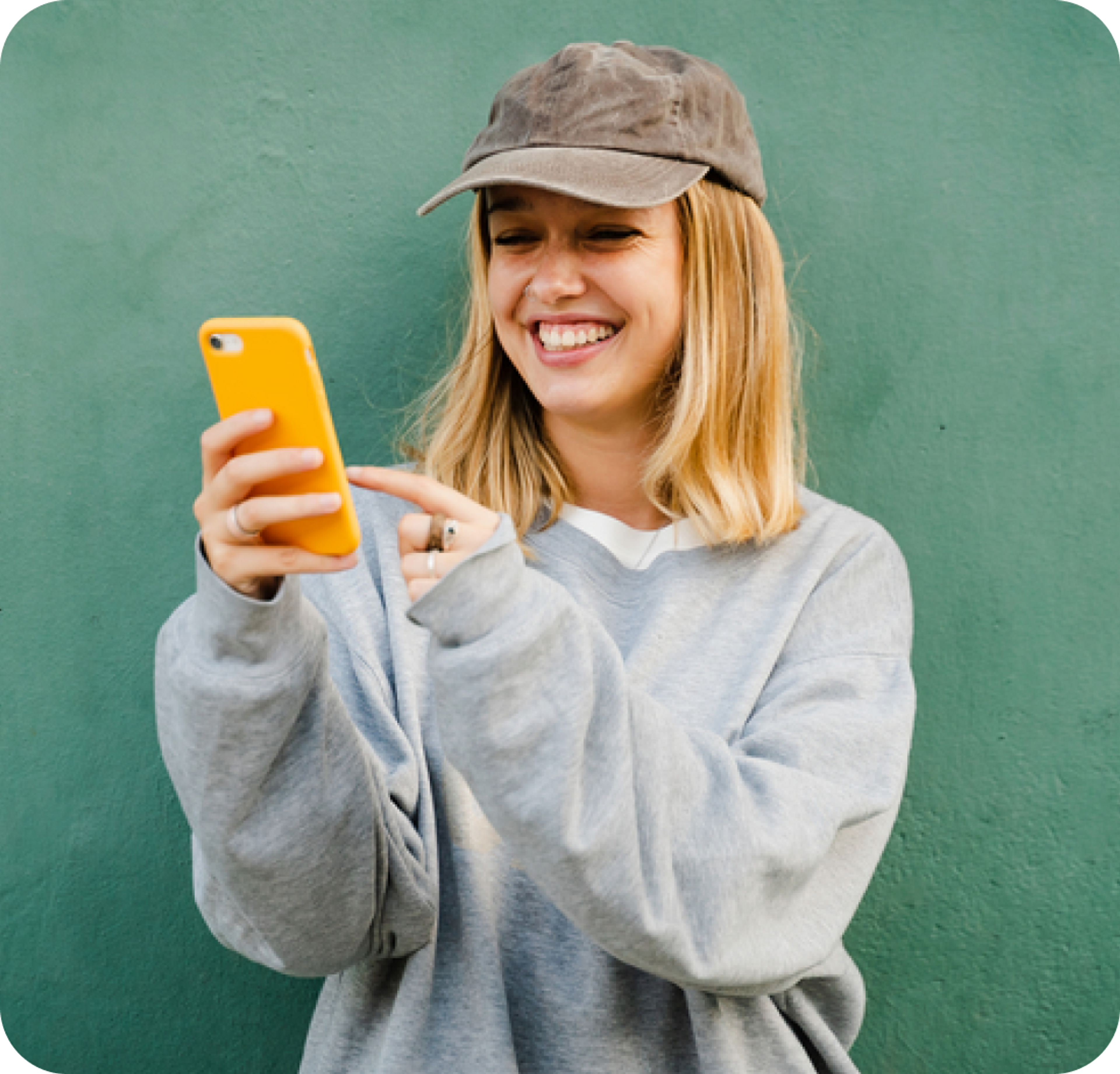 A photo of a woman smiling and looking at a phone