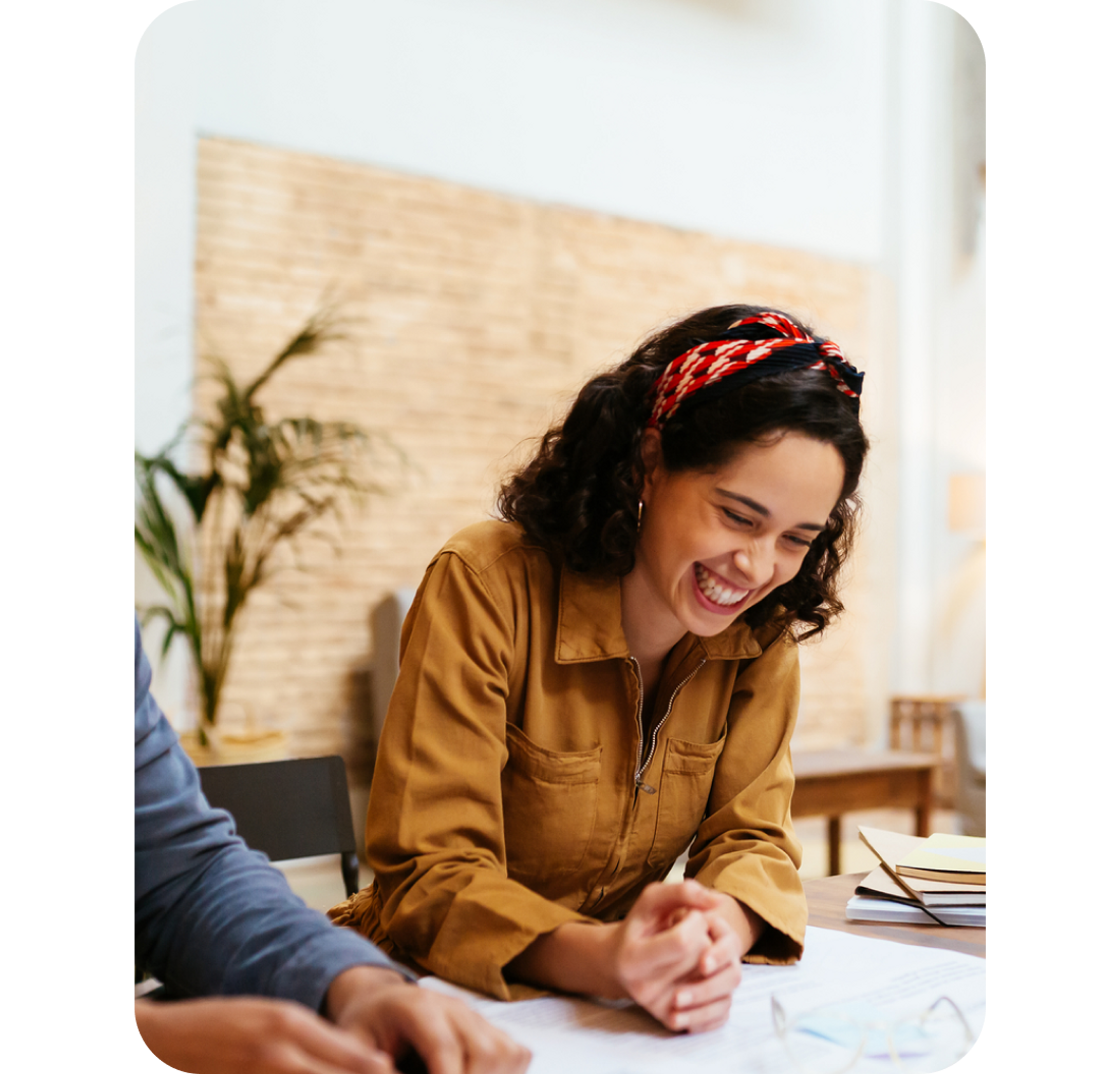 A photo of a woman smiling while sat at a desk