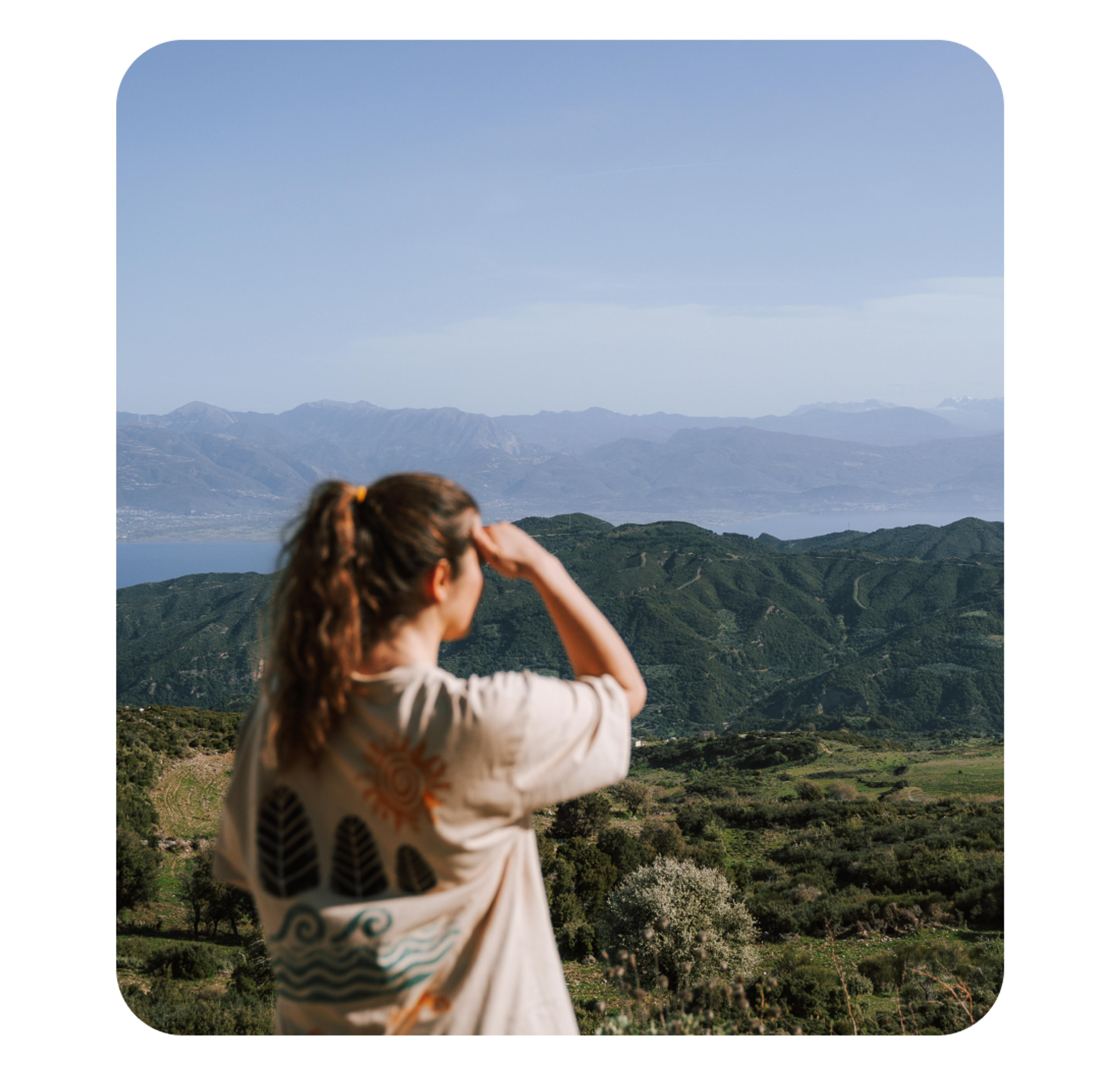 A photo of a woman staring out over a mountainous landscape