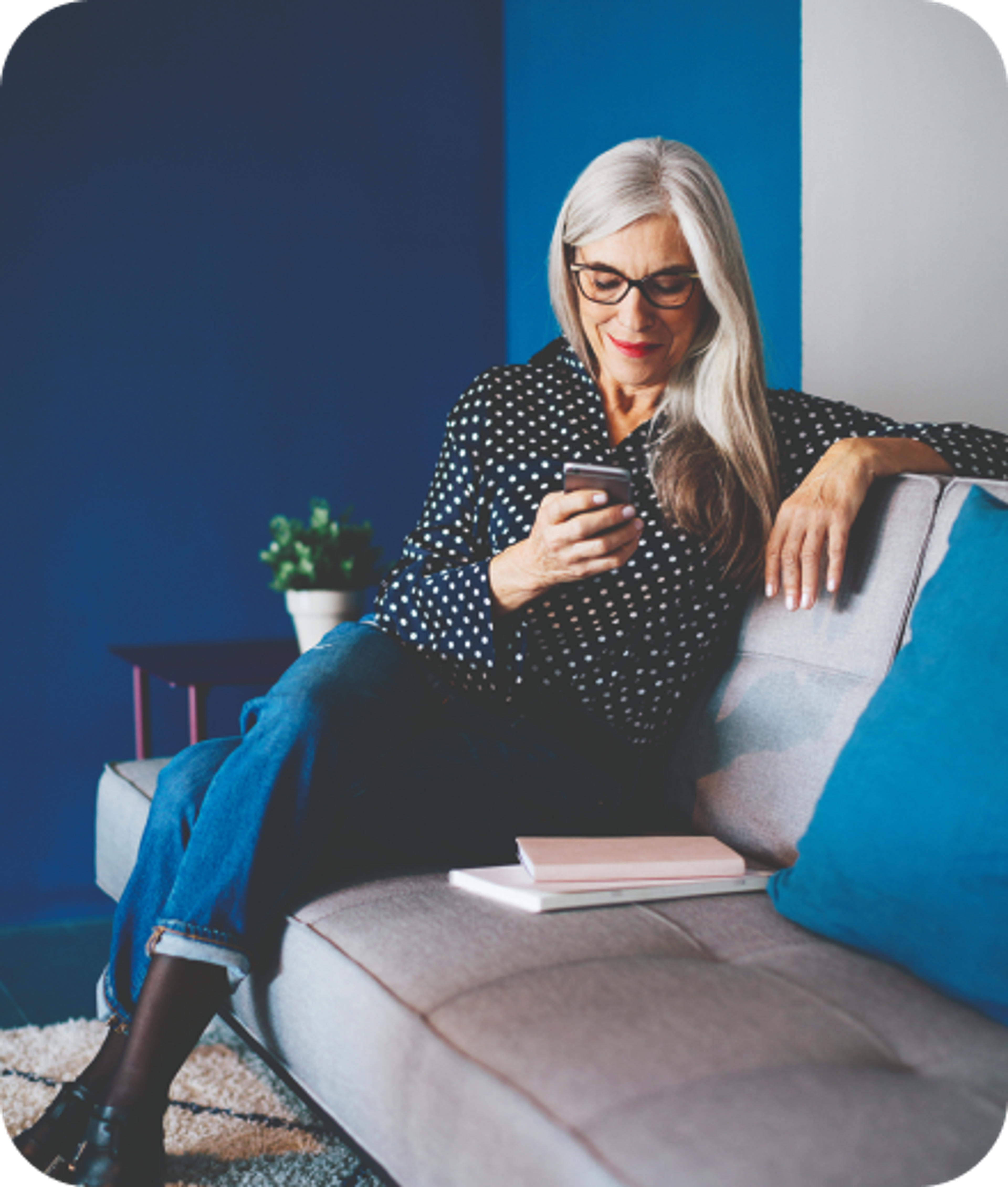 A close up headshot of a man smiling while looking at a phone