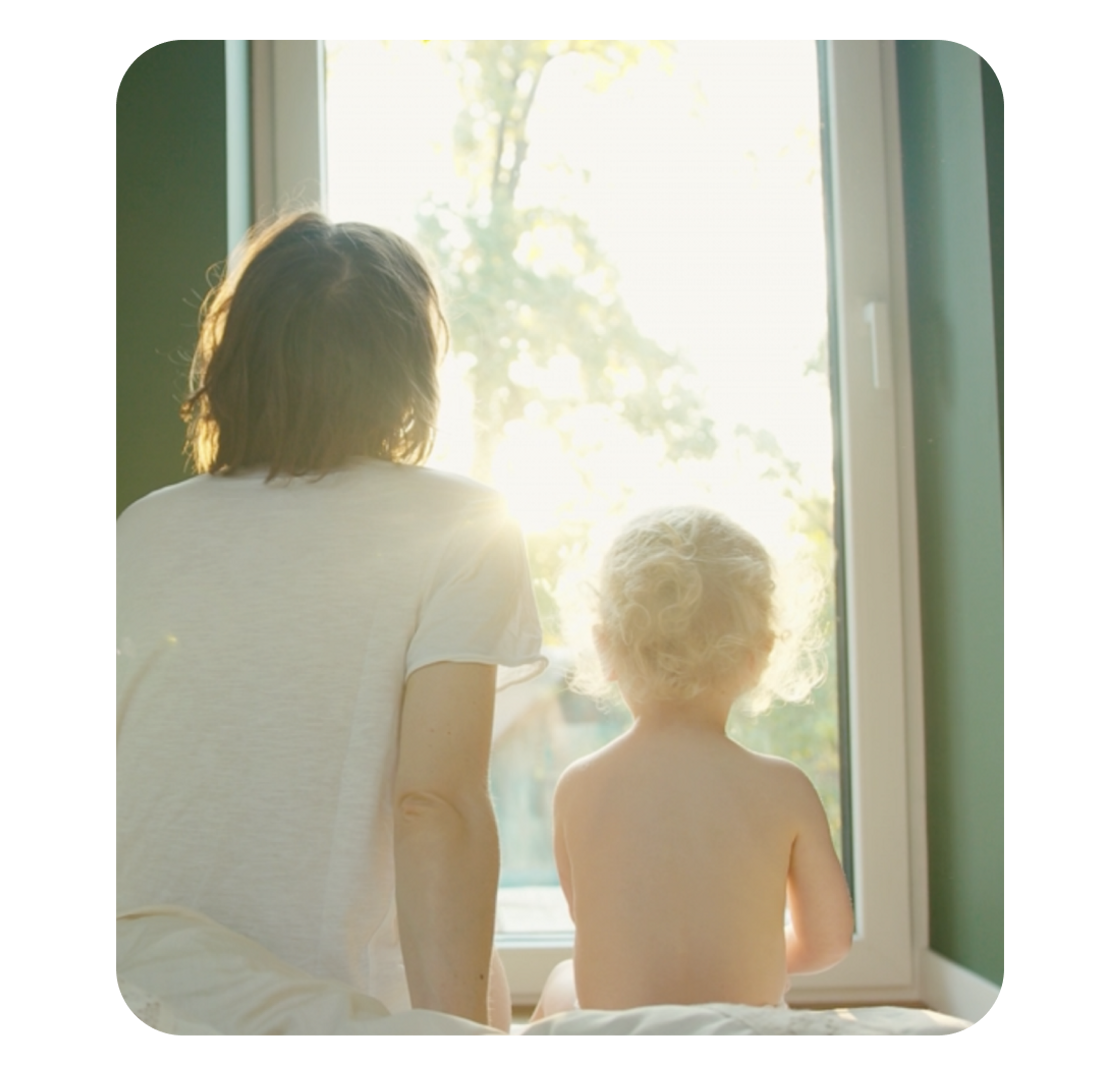 A photo of a woman and a child looking out of a window