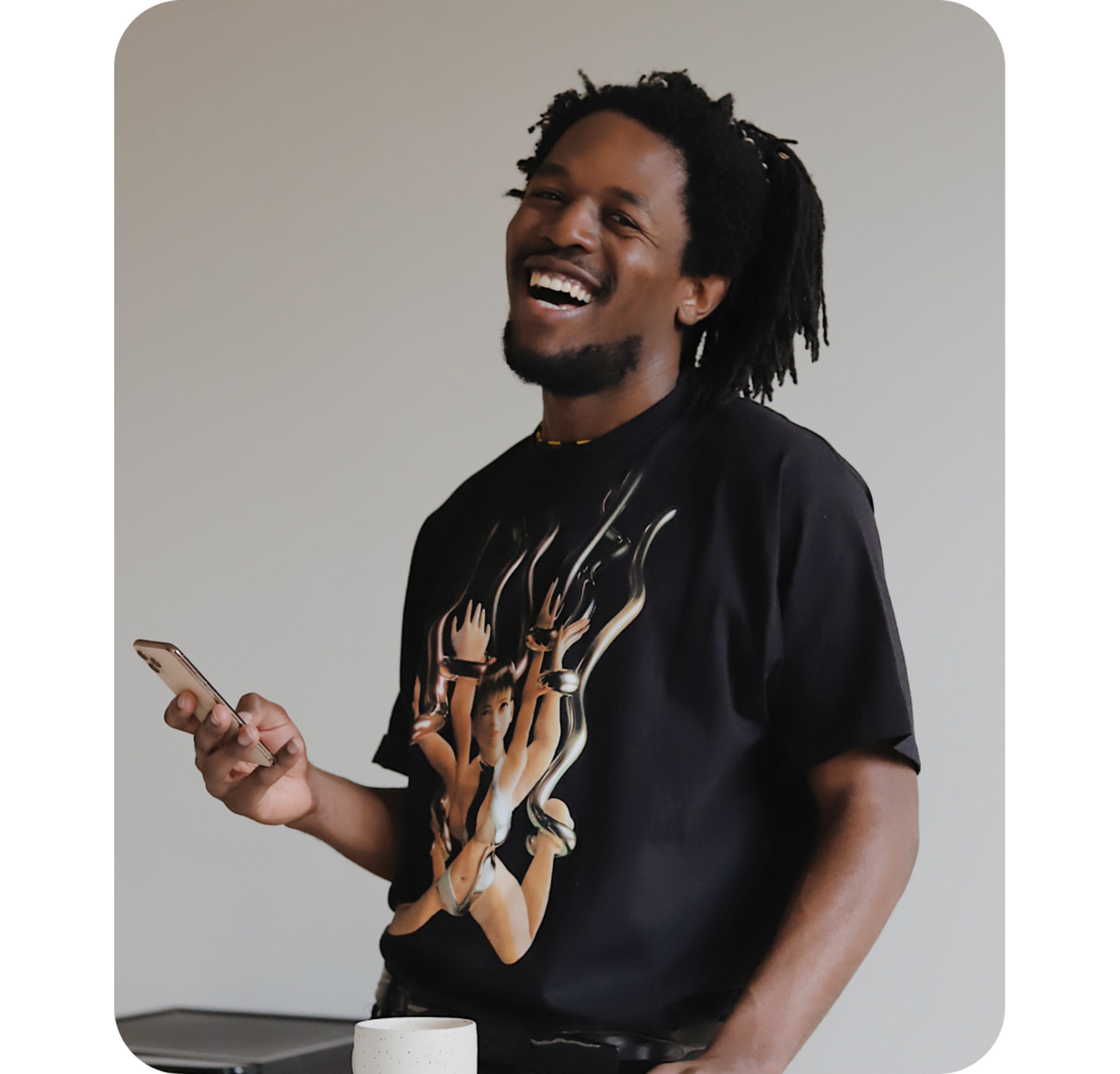A photo of a man laughing while holding a phone
