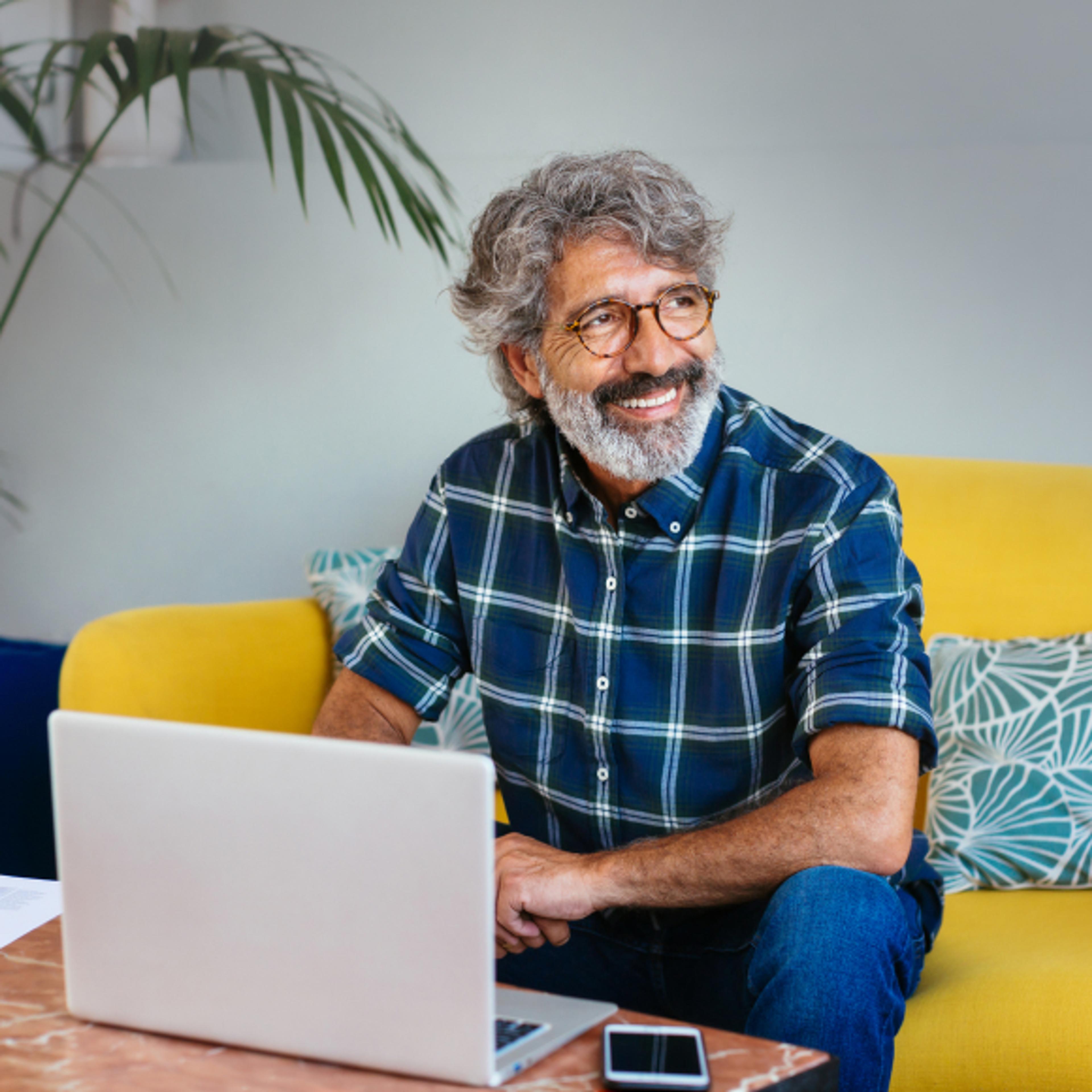 A photo of a man smiling and looking off to the right