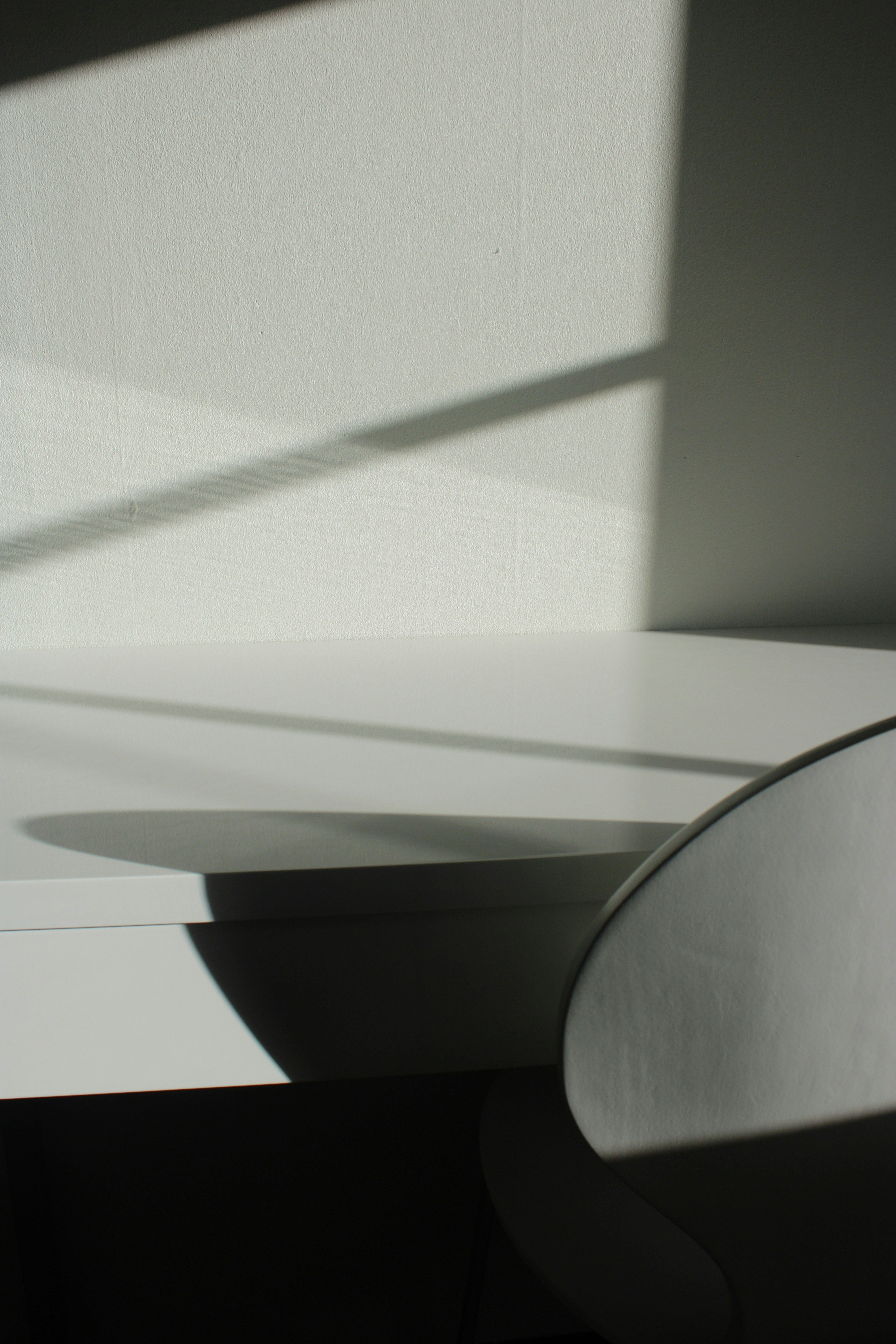 On the right, part of a chair is visible, its shadow falling on a table