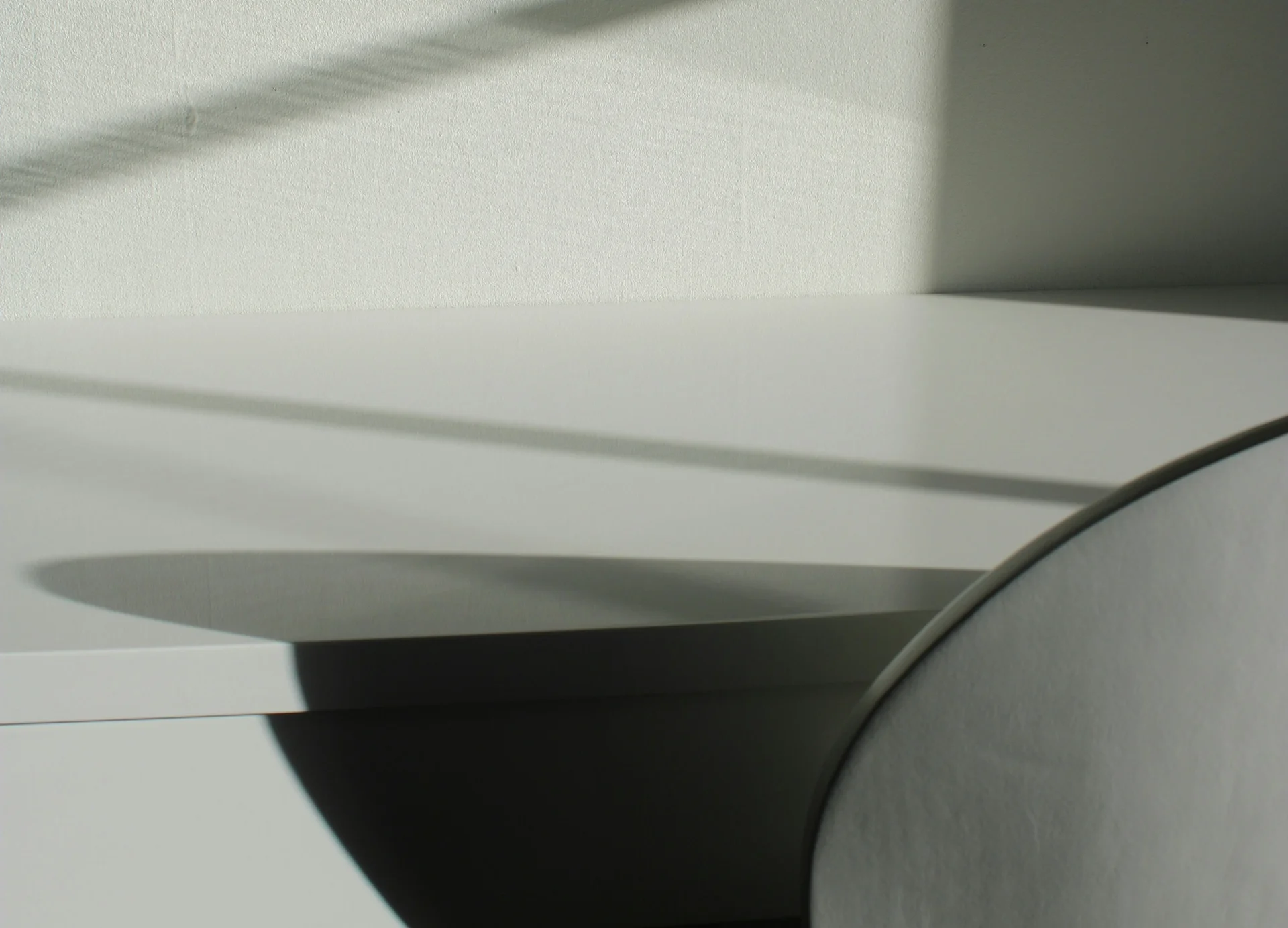 On the right, part of a chair is visible, its shadow falling on a table
