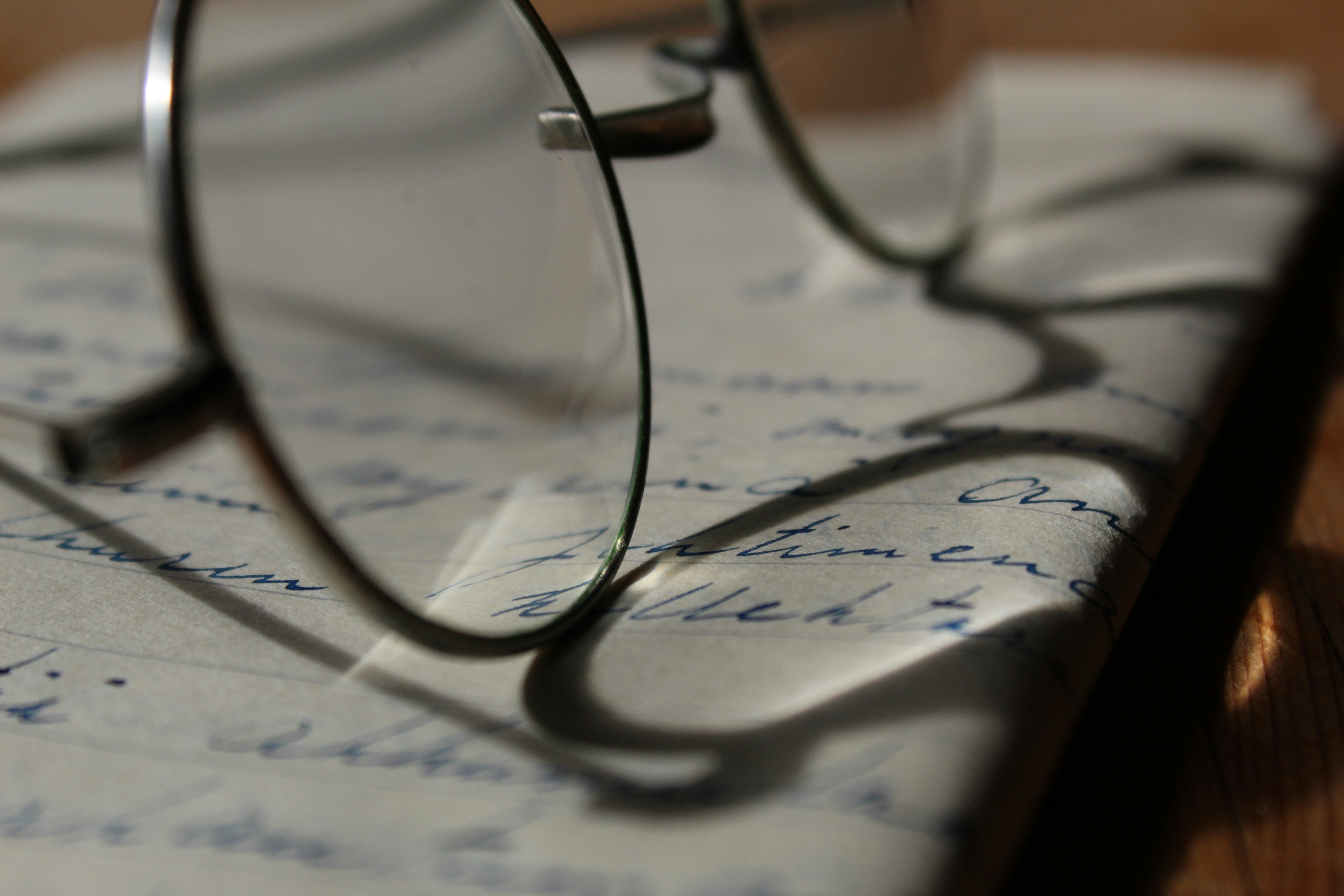 Close-up of glasses resting on a notebook with illegible notes