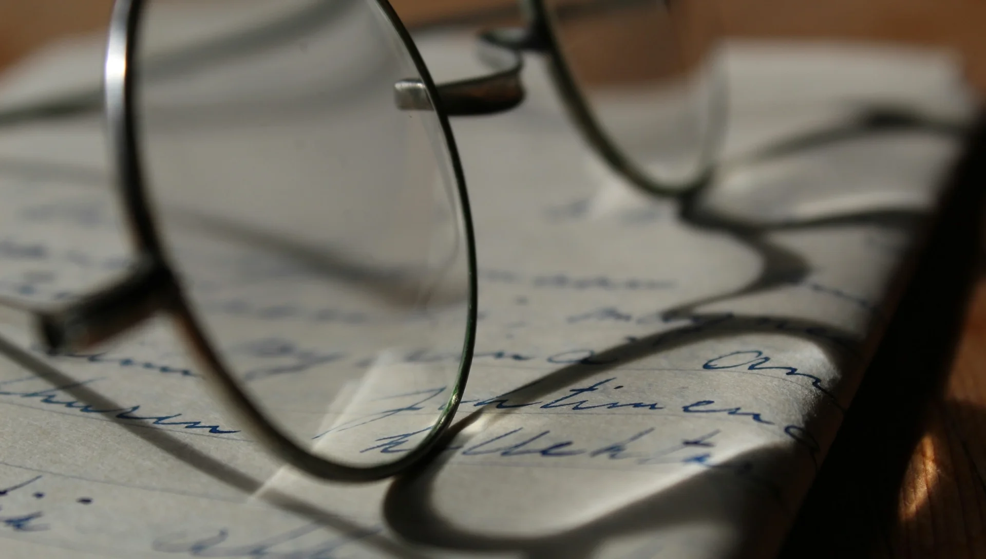 Close-up of glasses resting on a notebook with illegible notes