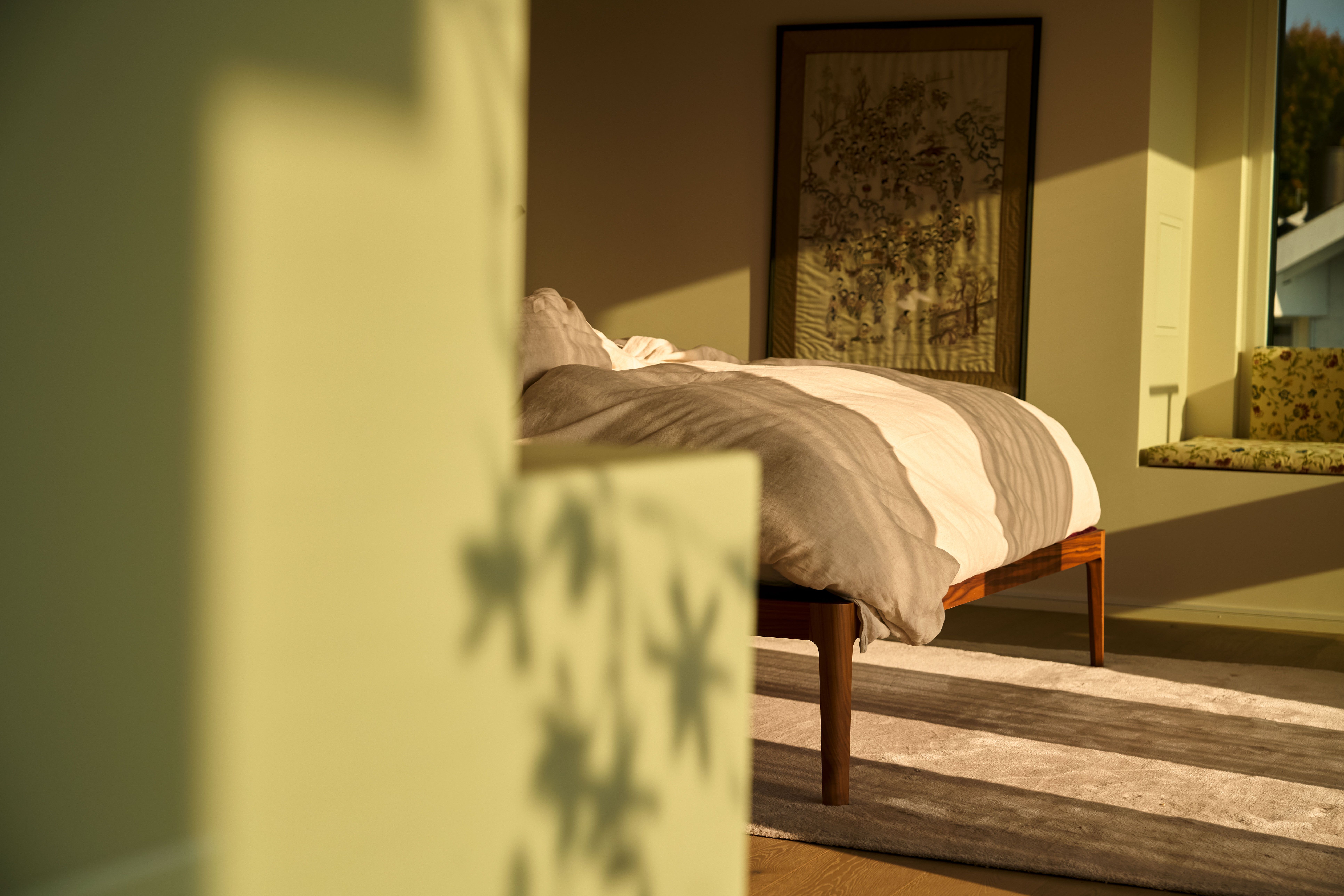 Soft shadows fall across the bed, dancing with the light