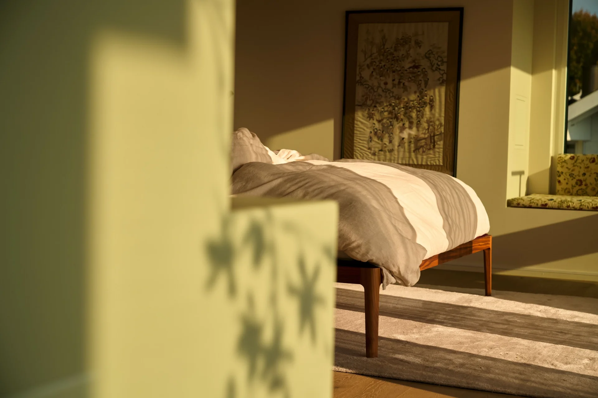 Soft shadows fall across the bed, dancing with the light