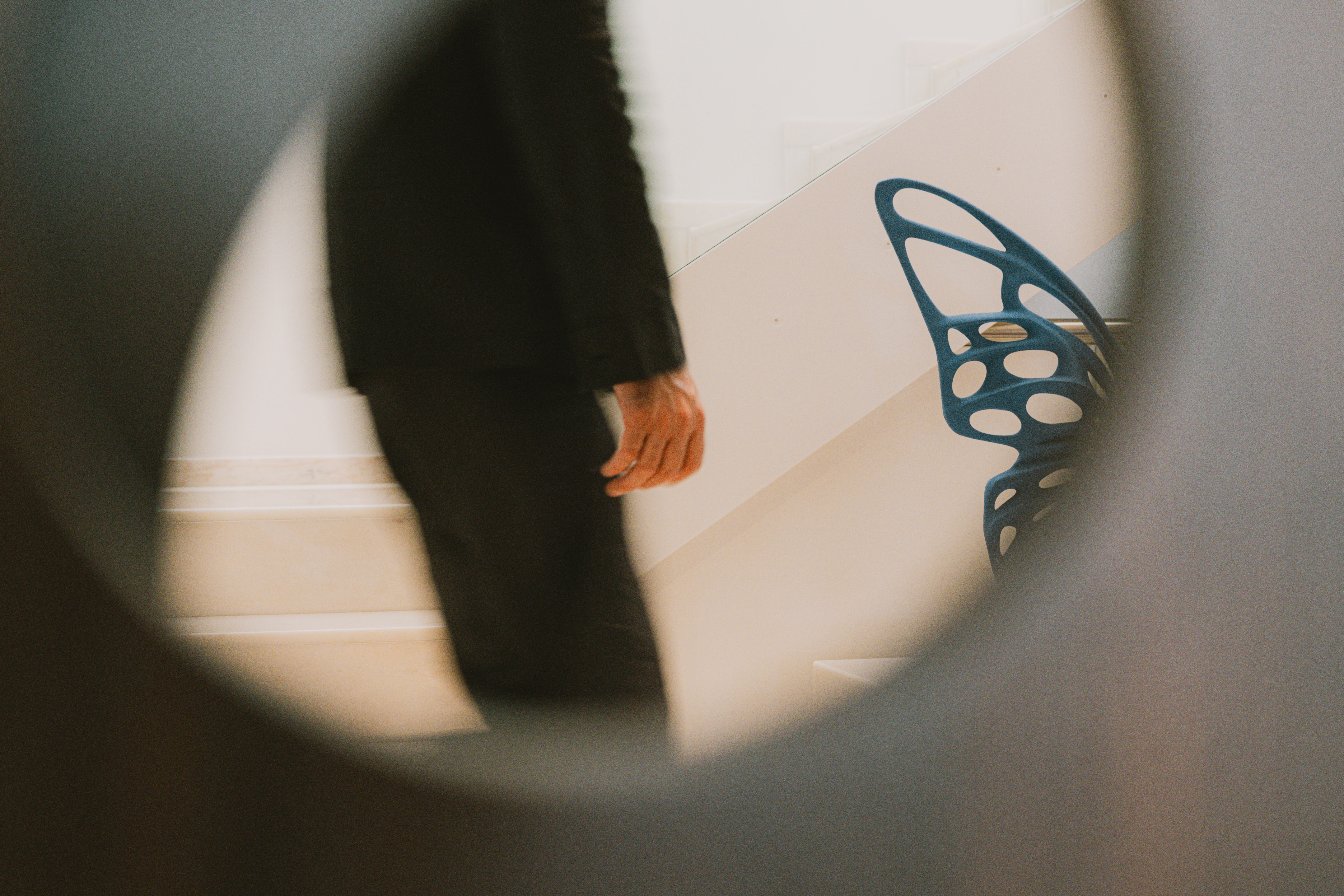 A view through a sliding door with holes. A side view of a man's upper body