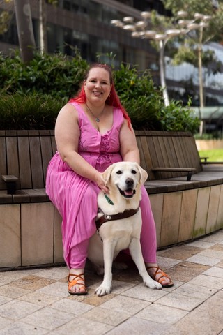 A Handler sitting with their Guide Dog.