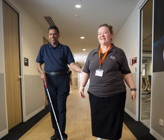 A Guide Dogs staff member walking with a Client