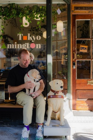 A person holding a puppy next to a donation dog.