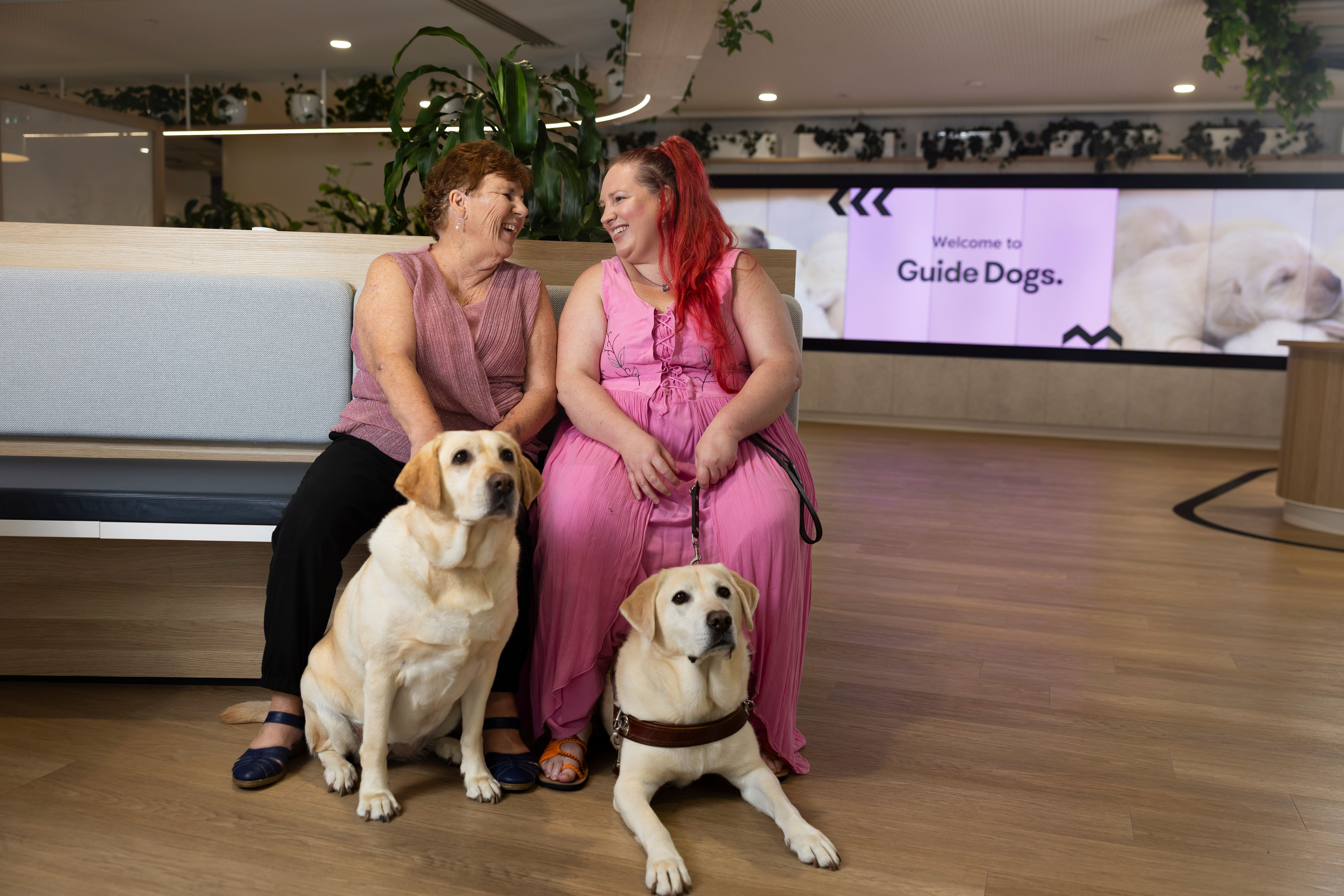 A mum and daughter with their two Guide Dogs. 
