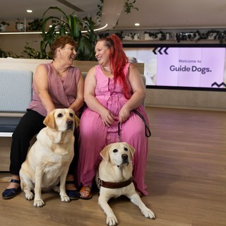 A mum and daughter with their two Guide Dogs.