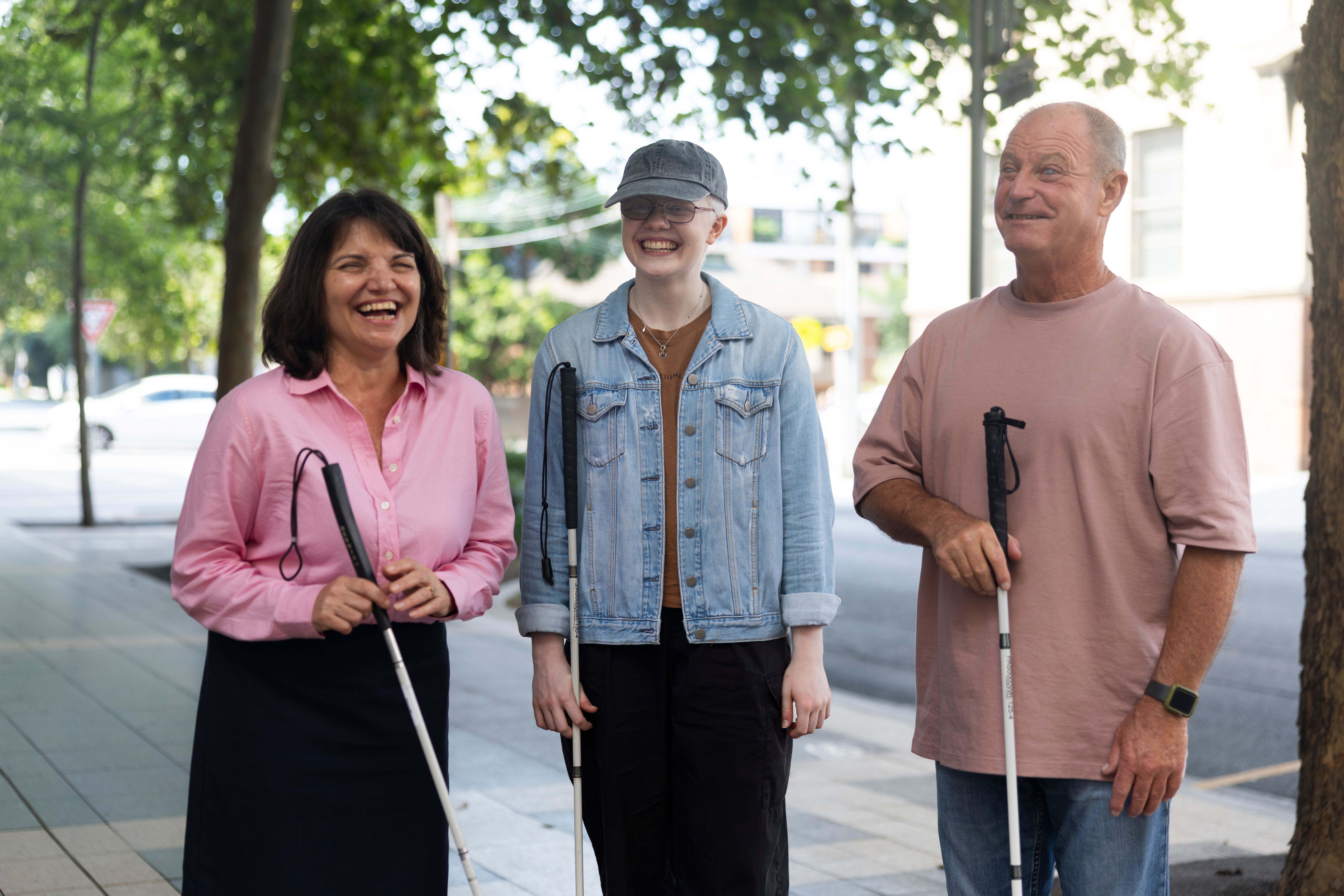 Three people standing with canes.