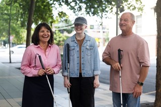 Three people standing with canes.
