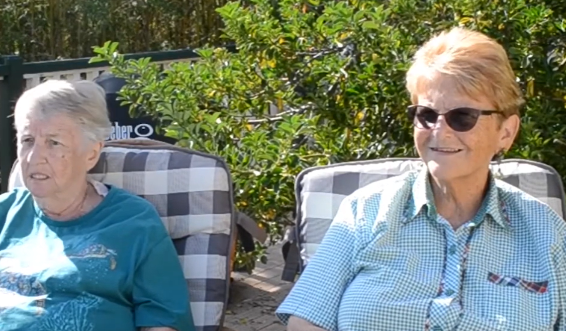 Two sisters sitting next to each other.