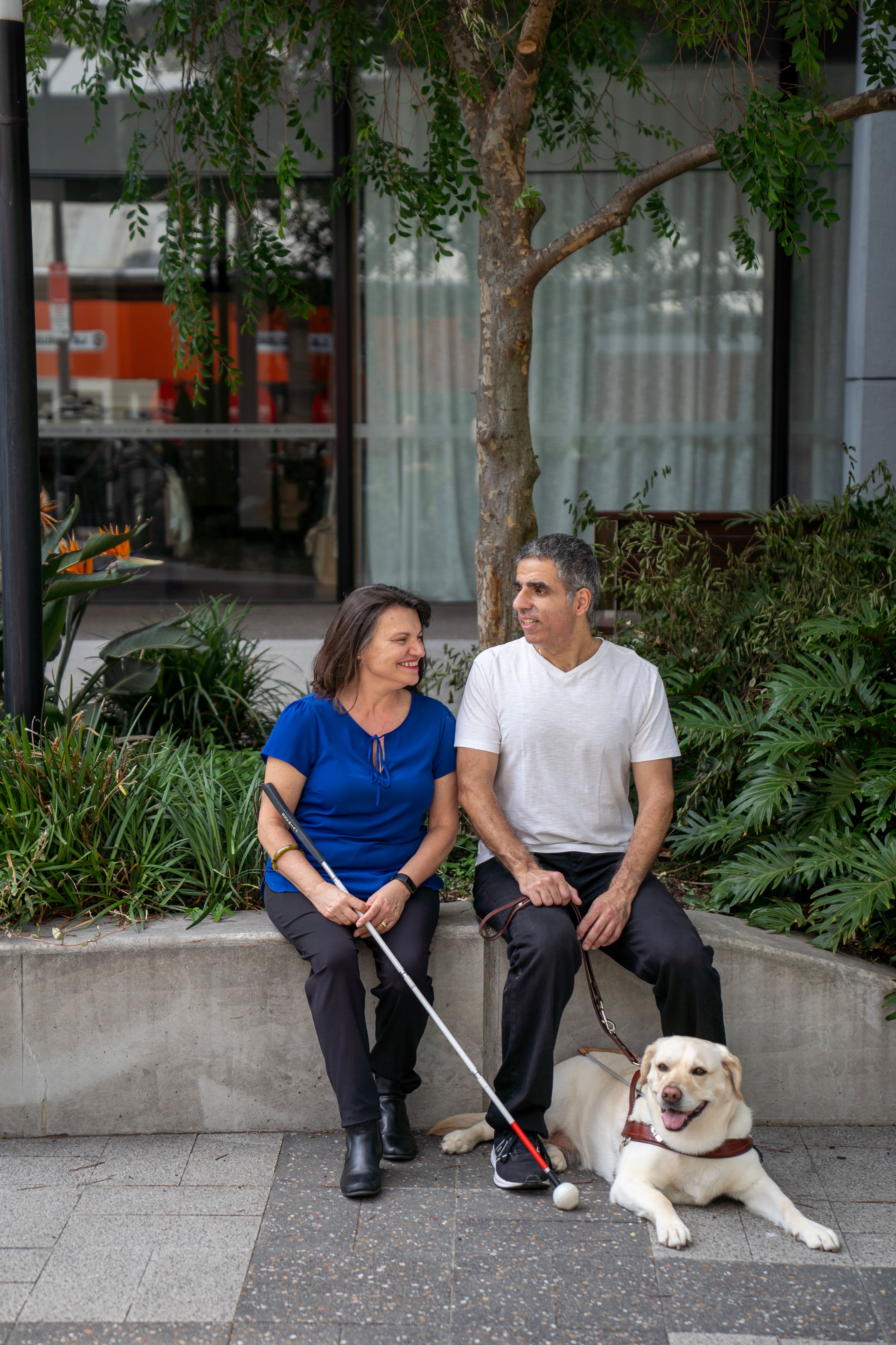 A Client using a white Cane to walk across a road.