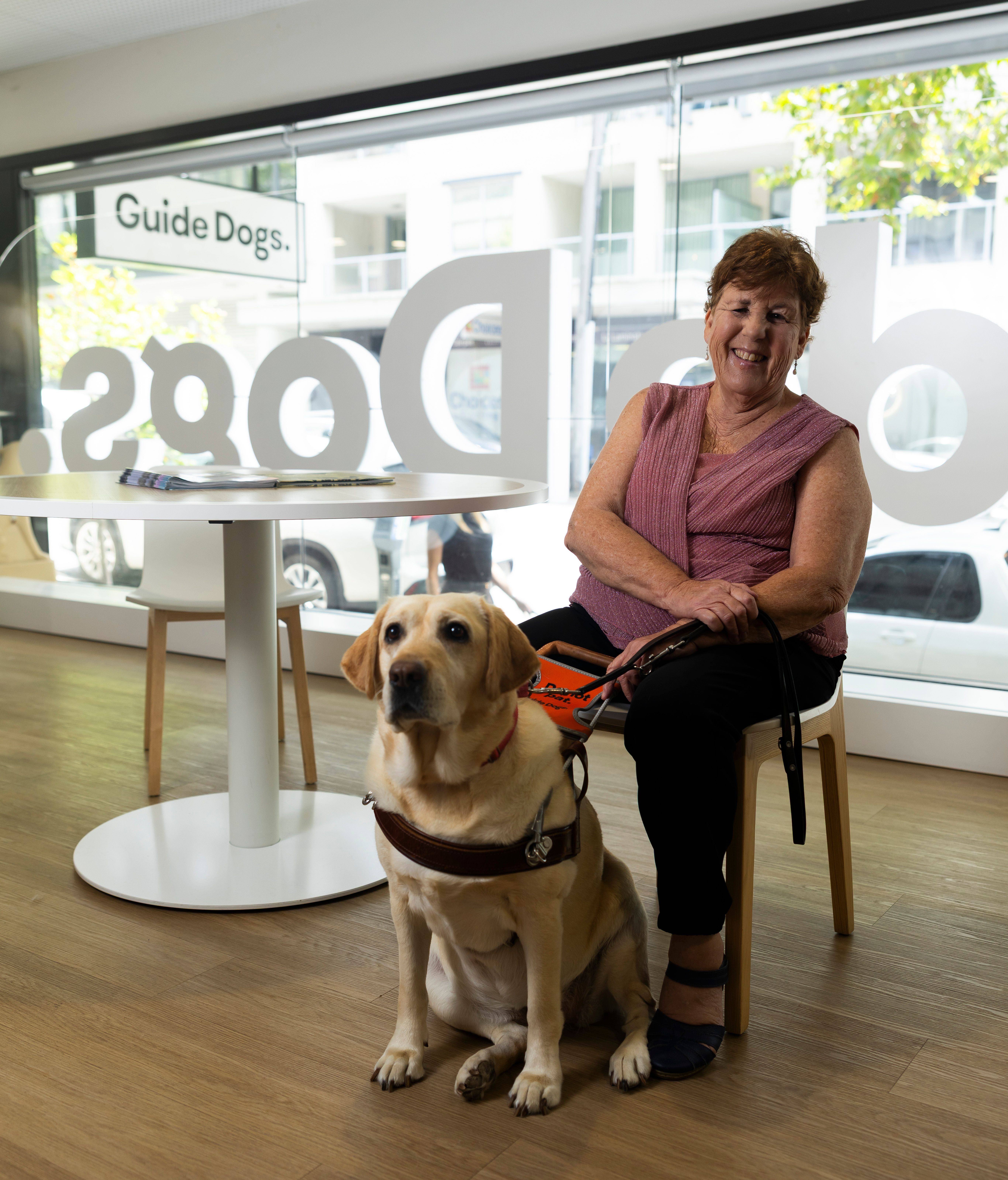A Handler sitting with her yellow Guide Dog. 