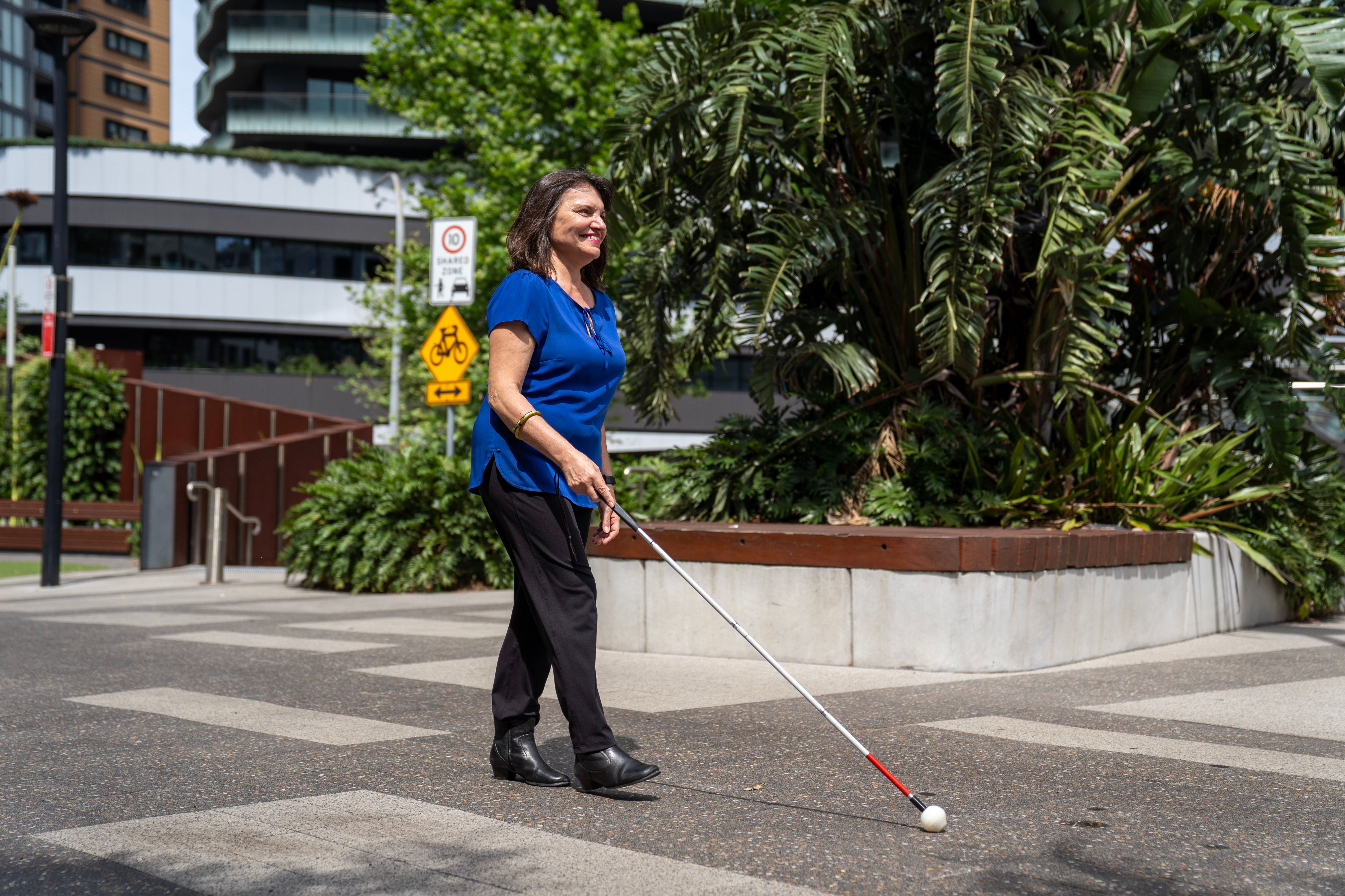 A person walking with their white cane.