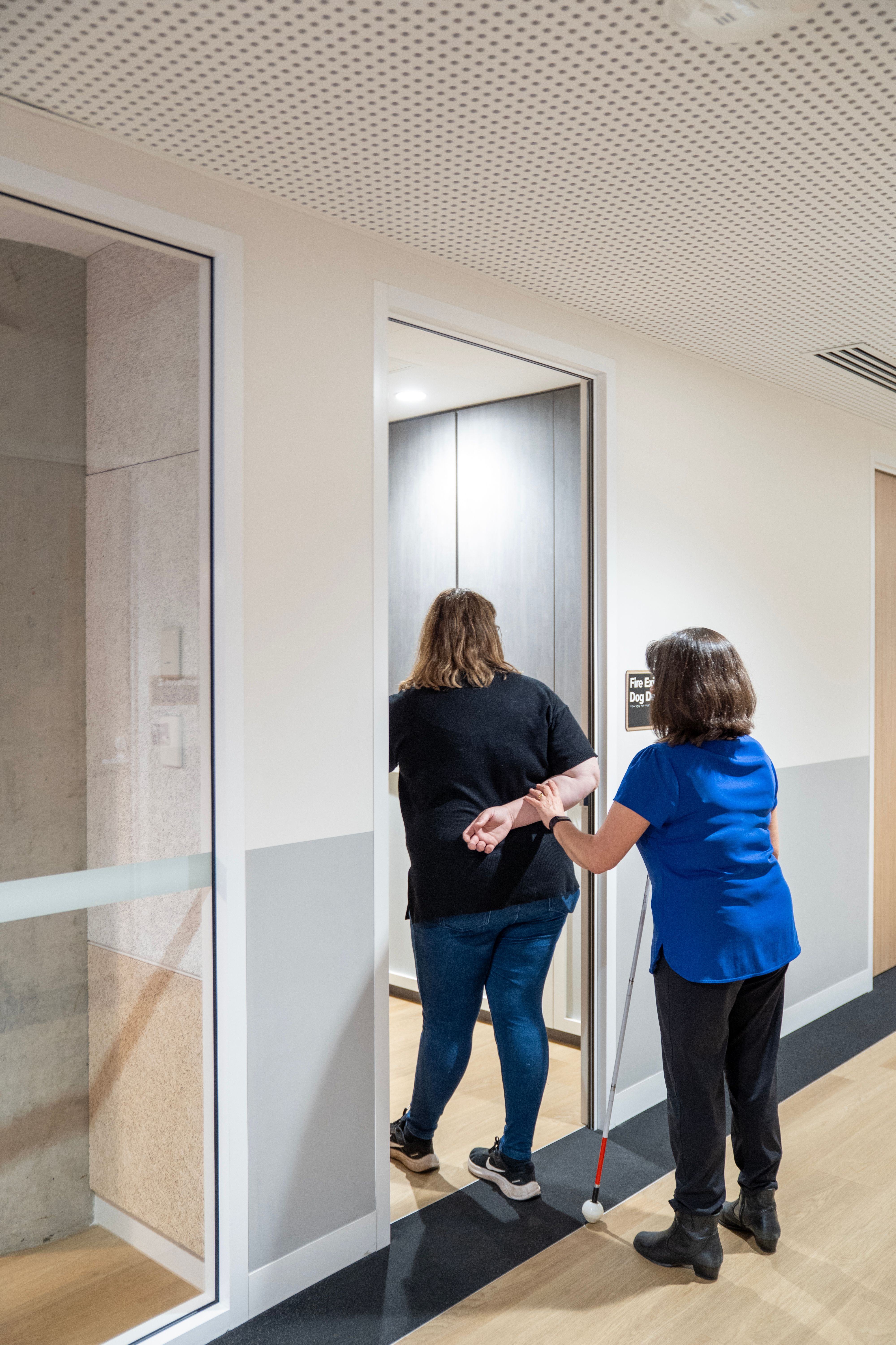 A person guiding another through the door. 