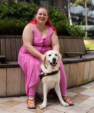 A Guide Dog Handler with her yellow Guide Dog.