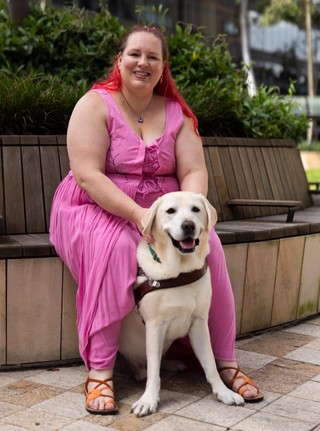 A Guide Dog Handler with her yellow Guide Dog.