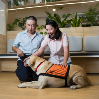 Two people petting a Therapy Dog.