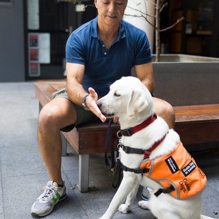 A Puppy Raiser sitting with their dog.