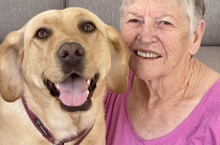 Barbara smiling with yellow Labrador Skye.