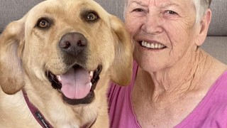 Barbara smiling with yellow Labrador Skye.