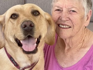 Barbara smiling with yellow Labrador Skye.