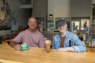 Two Clients sitting at a cafe and smiling.