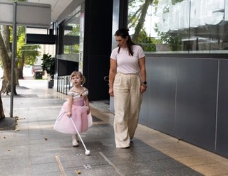 A staff member and a child walking together.